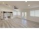Bright living room with built-in shelving, ceiling fan, and french doors to the backyard at 30517 N Maple Chase Dr, San Tan Valley, AZ 85143