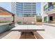 Rooftop ping pong area with a grill and bar setup, set against a modern building at 3131 N Central Ave # 7004, Phoenix, AZ 85012