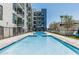 Community pool with a sun-shelf and lounge chairs, set against modern apartments at 3131 N Central Ave # 7004, Phoenix, AZ 85012