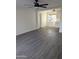 Open-concept living room with grey wood-look floors and access to the kitchen at 3421 W Montecito Ave, Phoenix, AZ 85017