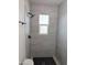 Modern walk-in shower featuring elegant tile work, a rain shower head, and sleek black fixtures at 3421 W Montecito Ave, Phoenix, AZ 85017