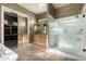 Well-lit primary bathroom with travertine floors, vanity, glass shower, and soaking tub at 3531 E Norwood Cir, Mesa, AZ 85213