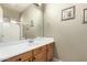 Bathroom with wood cabinets, large mirror, artwork and a shower/tub combo at 3531 E Norwood Cir, Mesa, AZ 85213