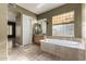Primary bathroom with a soaking tub, travertine floor, and vanity at 3531 E Norwood Cir, Mesa, AZ 85213