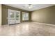 Bright bedroom with a travertine floor, shutters, and doors to the backyard at 3531 E Norwood Cir, Mesa, AZ 85213