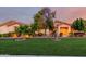 Charming single-story home featuring lush green lawn, mature trees, and inviting entryway at 3531 E Norwood Cir, Mesa, AZ 85213