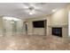 Open-concept living area with fireplace, large windows, and travertine flooring creates an inviting space at 3531 E Norwood Cir, Mesa, AZ 85213
