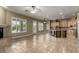 Open living space with a travertine floor, fireplace, natural light, and a view of the kitchen at 3531 E Norwood Cir, Mesa, AZ 85213
