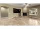 Cozy living room area with stone floors, modern ceiling fan, and a fireplace to enjoy those cooler nights at 3531 E Norwood Cir, Mesa, AZ 85213