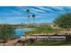 Scenic view of a lake in the community, complete with palm trees and mountain views at 3566 N 166Th Dr, Goodyear, AZ 85395