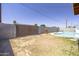 Backyard featuring a refreshing pool, secure wooden gate, and easy-to-maintain landscaping at 3823 W Rose Ln, Phoenix, AZ 85019