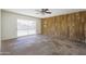 Spacious living room featuring wood paneled wall and sliding glass door at 3823 W Rose Ln, Phoenix, AZ 85019