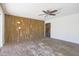 Living room with wood paneled accent wall and ceiling fan at 3823 W Rose Ln, Phoenix, AZ 85019