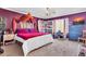 Bedroom features a dresser with a television, chandelier, white shelves, and a vibrant accent wall at 40638 N High Meadows Dr, San Tan Valley, AZ 85140
