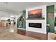 Open living room showcasing a modern fireplace, a mounted TV, and sleek hardwood flooring at 40638 N High Meadows Dr, San Tan Valley, AZ 85140