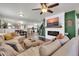Cozy living room featuring an electric fireplace, a comfortable sofa, and an open layout to the kitchen at 40638 N High Meadows Dr, San Tan Valley, AZ 85140