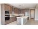 A modern kitchen features stainless steel appliances, a central island, and lots of storage inside wood finish cabinetry at 4227 W Adobe Dr, Eloy, AZ 85131
