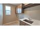 Well-lit laundry room features wood floors, hanging rack, modern sink, and tan cabinets at 4227 W Adobe Dr, Eloy, AZ 85131