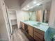 Bathroom featuring dual sinks, a vanity, and a walk-in closet with ample storage space at 4332 E Stanford Ave, Gilbert, AZ 85234