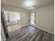 Bedroom featuring wood-look floors, a window with curtains, and open access to other rooms at 4332 E Stanford Ave, Gilbert, AZ 85234