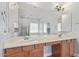 Spacious bathroom with double sinks, large mirror, and modern lighting fixtures at 43502 W Kramer Ln, Maricopa, AZ 85138