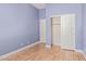 Bedroom with blue walls, laminate flooring, closet, and white trim at 43502 W Kramer Ln, Maricopa, AZ 85138
