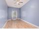 Comfortable bedroom with wood-look flooring, light-colored walls and a ceiling fan at 43502 W Kramer Ln, Maricopa, AZ 85138