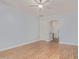 Bright bedroom with light-colored walls, wood-look flooring, ceiling fan, and access to a bathroom at 43502 W Kramer Ln, Maricopa, AZ 85138