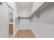 Walk-in closet with wooden shelving and access to the bathroom at 43502 W Kramer Ln, Maricopa, AZ 85138