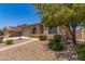 Attractive home exterior showcasing desert landscaping, brick walkway, and mature tree shading the property at 43502 W Kramer Ln, Maricopa, AZ 85138