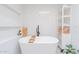 Bright bathroom features white tile, a soaking tub, recessed shelving, and a modern freestanding shelf at 4842 E Fairmount Ave, Phoenix, AZ 85018
