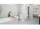 A serene bathroom with a modern soaking tub, black fixtures, and stylish black-and-white patterned floors at 4842 E Fairmount Ave, Phoenix, AZ 85018