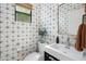Stylish powder room featuring patterned tile walls, a modern sink, and a decorative mirror at 4842 E Fairmount Ave, Phoenix, AZ 85018