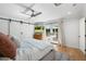 Bright bedroom with sliding barn doors, ceiling fan, and access to the outdoor pool and patio at 4842 E Fairmount Ave, Phoenix, AZ 85018