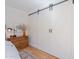 Bedroom with white barn door to closet and wood floors at 4842 E Fairmount Ave, Phoenix, AZ 85018