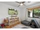 Bright playroom features a flat screen television, window, ceiling fan, play tent, soft rug and basket shelving unit at 4842 E Fairmount Ave, Phoenix, AZ 85018