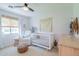 Cozy Bedroom with a white crib, a chair, and a round pouf at 4842 E Fairmount Ave, Phoenix, AZ 85018