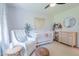 Bright Bedroom featuring patterned wall paper, white crib, chair, and light wood furniture at 4842 E Fairmount Ave, Phoenix, AZ 85018