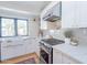 Bright kitchen featuring white cabinetry, stainless steel appliances, a farmhouse sink, and a stylish geometric tile backsplash at 4842 E Fairmount Ave, Phoenix, AZ 85018