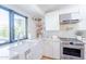 Beautiful kitchen with white cabinets, stainless steel range, farmhouse sink, and geometric tile backsplash at 4842 E Fairmount Ave, Phoenix, AZ 85018