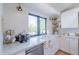 Bright kitchen showcasing white cabinets, a stainless steel dishwasher, farmhouse sink, and stylish wall tiling at 4842 E Fairmount Ave, Phoenix, AZ 85018