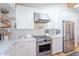 Modern kitchen with stainless steel appliances, white cabinets, stone countertops, and open shelving at 4842 E Fairmount Ave, Phoenix, AZ 85018