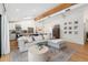 Bright, open living room featuring hardwood floors, a modern couch, and an adjacent kitchen with white cabinets at 4842 E Fairmount Ave, Phoenix, AZ 85018