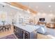 Open-concept living space with wood beams, modern lighting, and a large island with seating at 4842 E Fairmount Ave, Phoenix, AZ 85018