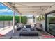 Relaxing poolside patio with comfortable seating under a stylish pergola and a mounted TV for outdoor entertainment at 4842 E Fairmount Ave, Phoenix, AZ 85018