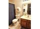 Well-lit bathroom features a toilet, vanity with sink, mirror, and decorative wreath at 5136 E Evergreen St # 1053, Mesa, AZ 85205