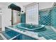Unique teal soaking tub surrounded by blue tiled steps and glass block window at 538 S Macdonald --, Mesa, AZ 85210