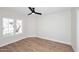 Bright bedroom features wood look flooring, neutral colored walls, and plenty of natural light from the window at 705 W Country Estates Ave, Gilbert, AZ 85233