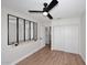 Bedroom features wood look floors, a ceiling fan, a wall mirror and a closet with white doors at 705 W Country Estates Ave, Gilbert, AZ 85233