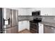 Bright kitchen features stainless steel appliances, granite countertops, a grey backsplash, and plenty of white cabinets at 705 W Country Estates Ave, Gilbert, AZ 85233